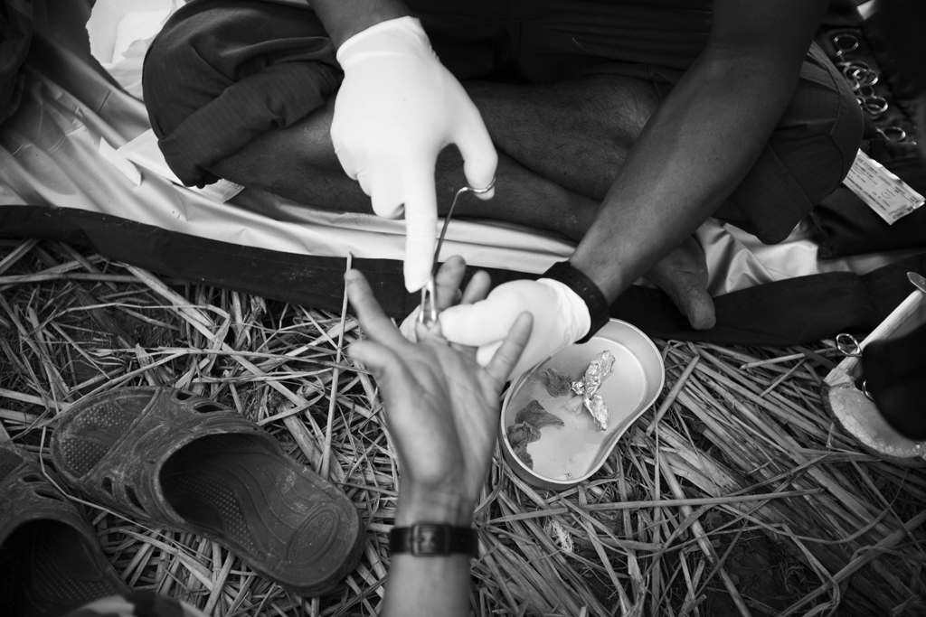 A FBR team medic performs minor surgery on a local villager at a temporary clinic set up for the people of local villages in Karen State, 5th Brigade controlled teritory.